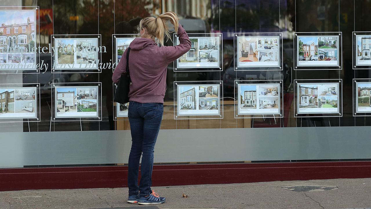 Woman looking in an estate agent&amp;#039;s window