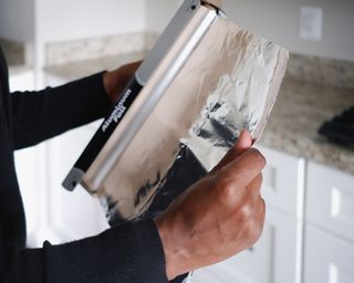 Close-up of unrecognizable black woman removing aluminum foil from container