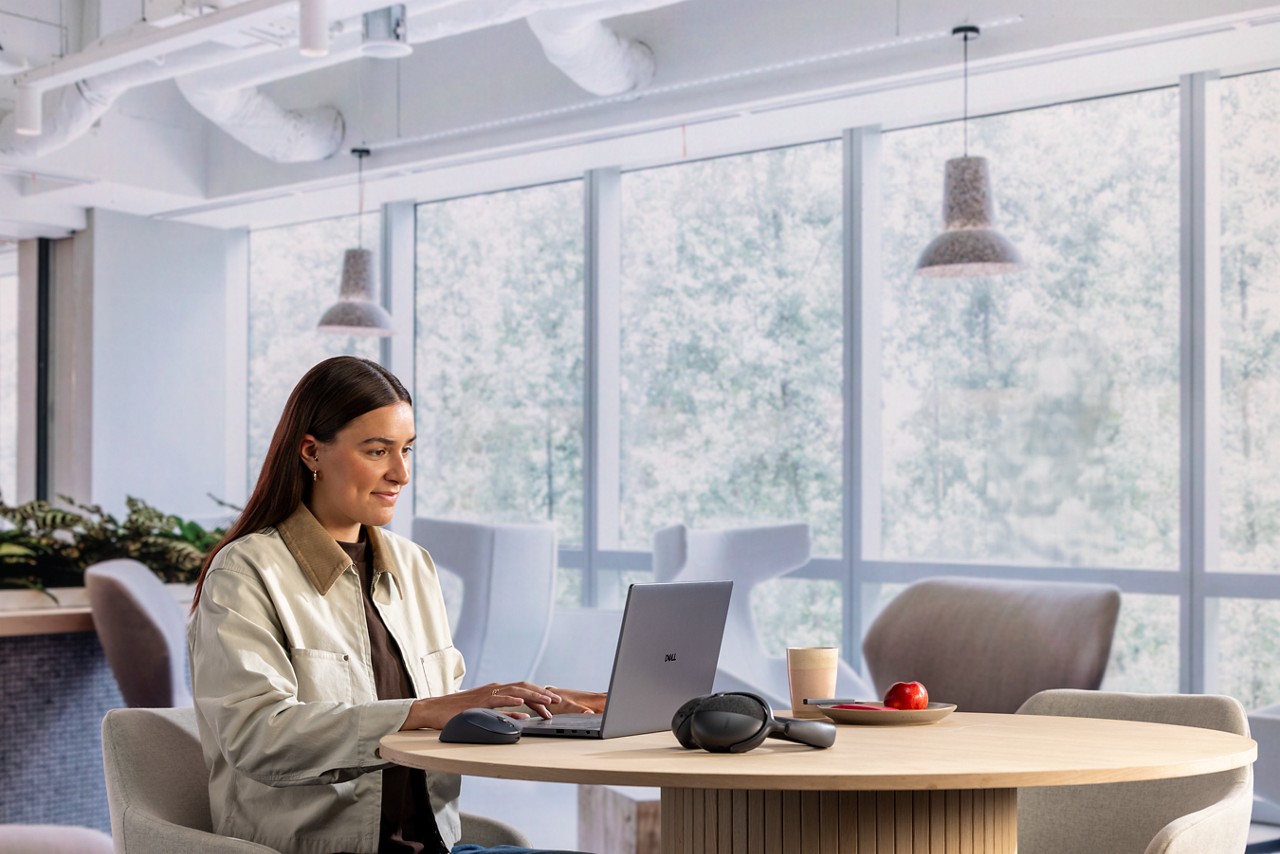 Woman working at Dell laptop in modern surroundings