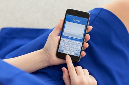 Alushta, Russia - December 3, 2014: Woman holding a iPhone 6 Space Gray with service PayPal on the screen. iPhone 6 was created and developed by the Apple inc.