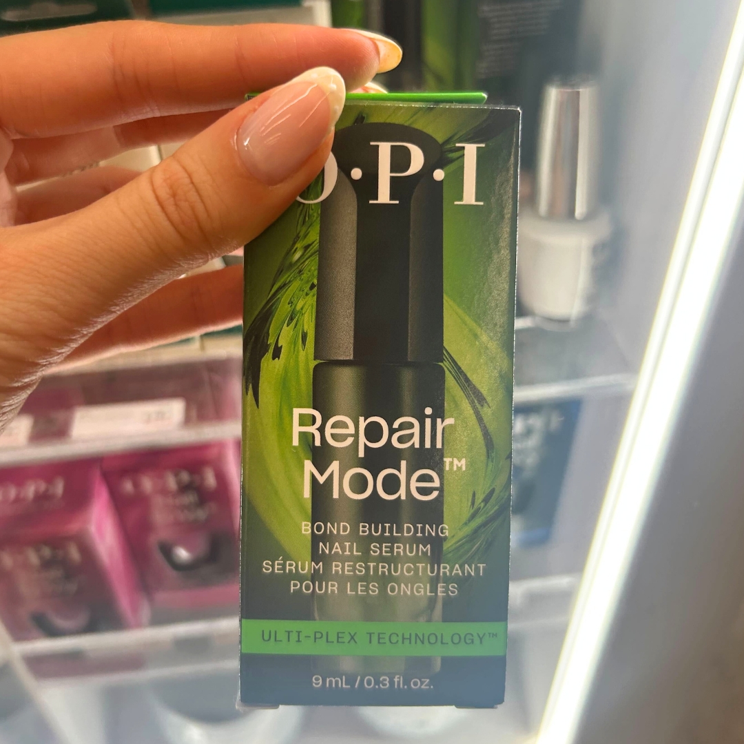 Hand holding box of OPI Repair Mode Strengthening Nail Polish in World Duty Free