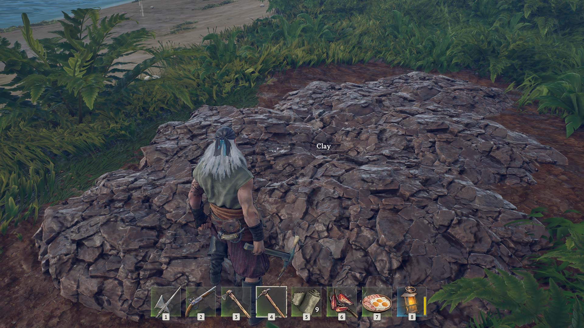 A clay deposit in Windrose. It's a muddy patch of dirt that stands out from surrounding grass and sand.