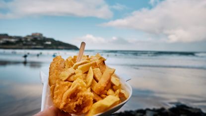 fish and chips in front of a beach