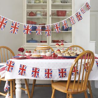 room with bunting flag decoration and food on table with chairs