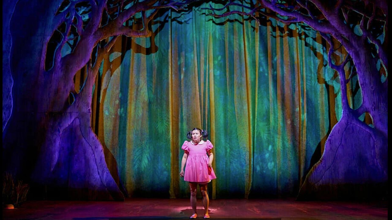 Mei (Mei Mac), wearing a pink dress, on stage in My Neighbour Totoro