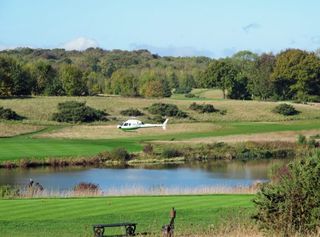 The helicopter shuttle arrives on the 18th of the Heritage Course