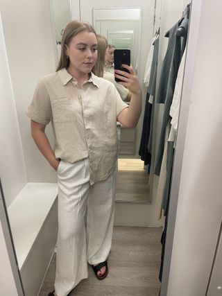 Woman in dressing room wears linen shirt and linen trousers