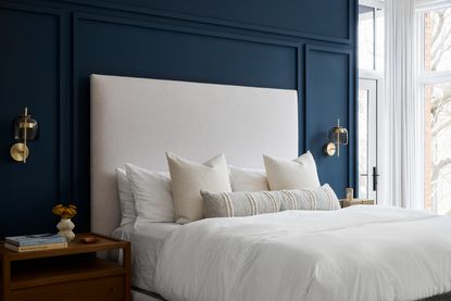 A bedroom with a navy blue accent wall