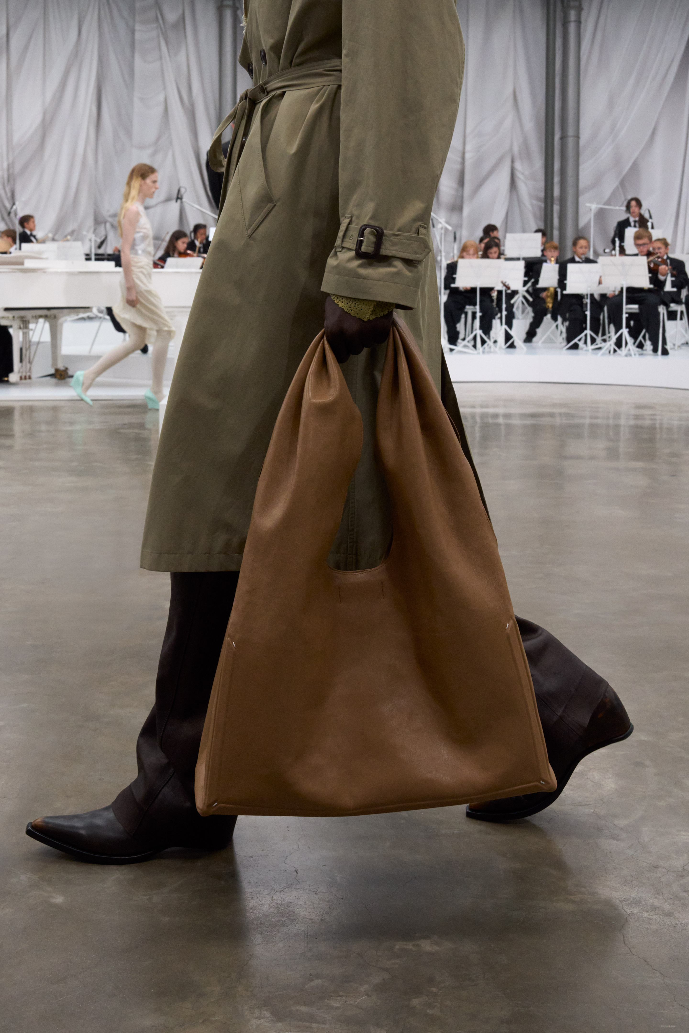 A close-up image of a model at the S/S 26 Maison Margiela show carrying a slouchy, oversized bag.