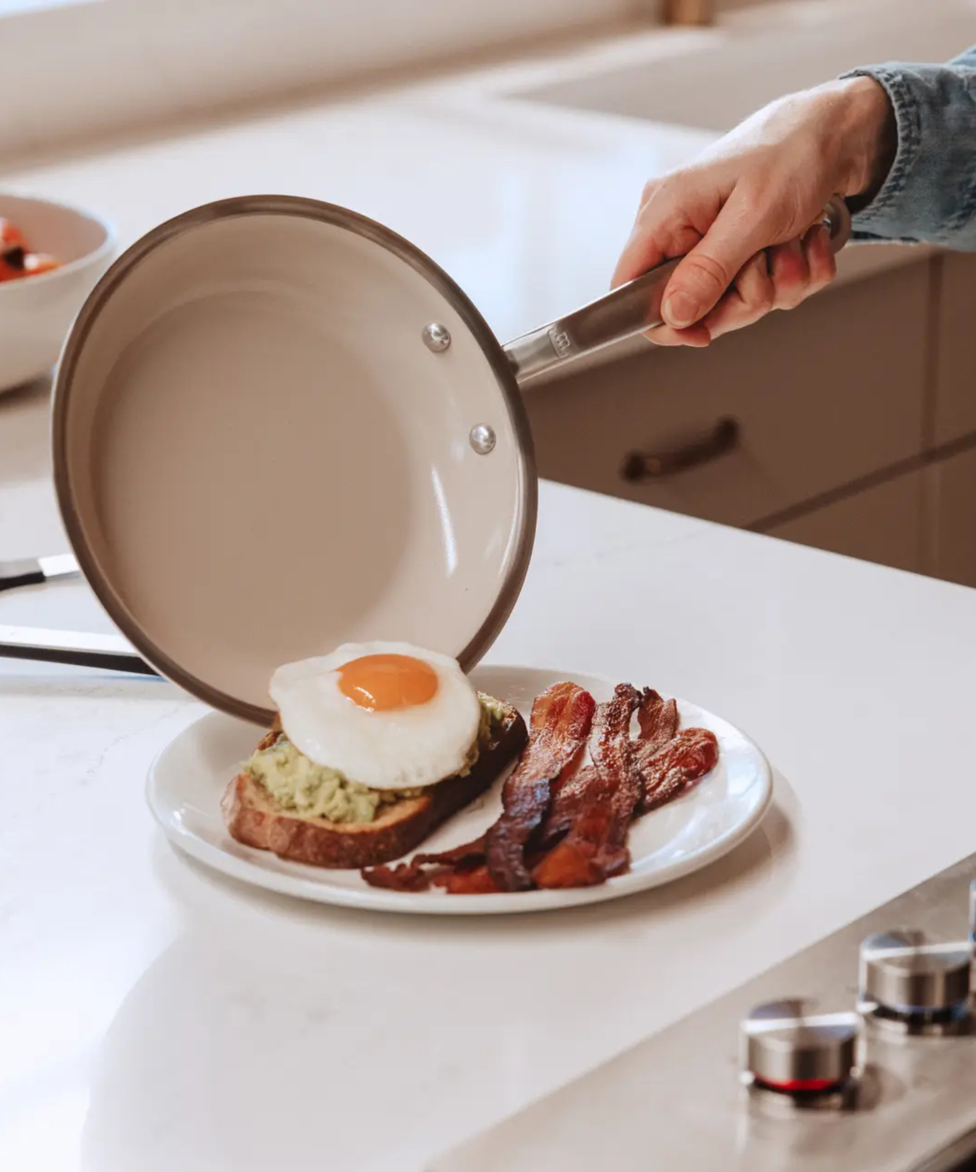 Tipping a fried egg out of a Made In CeramiClad pan