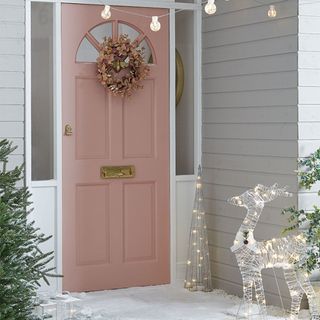 Outdoor Christmas lighting ideas with pink door and wreath