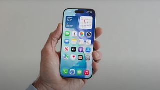 A screenshot of WWDC 2025 showing the redesigned iPhone homepage in-hand