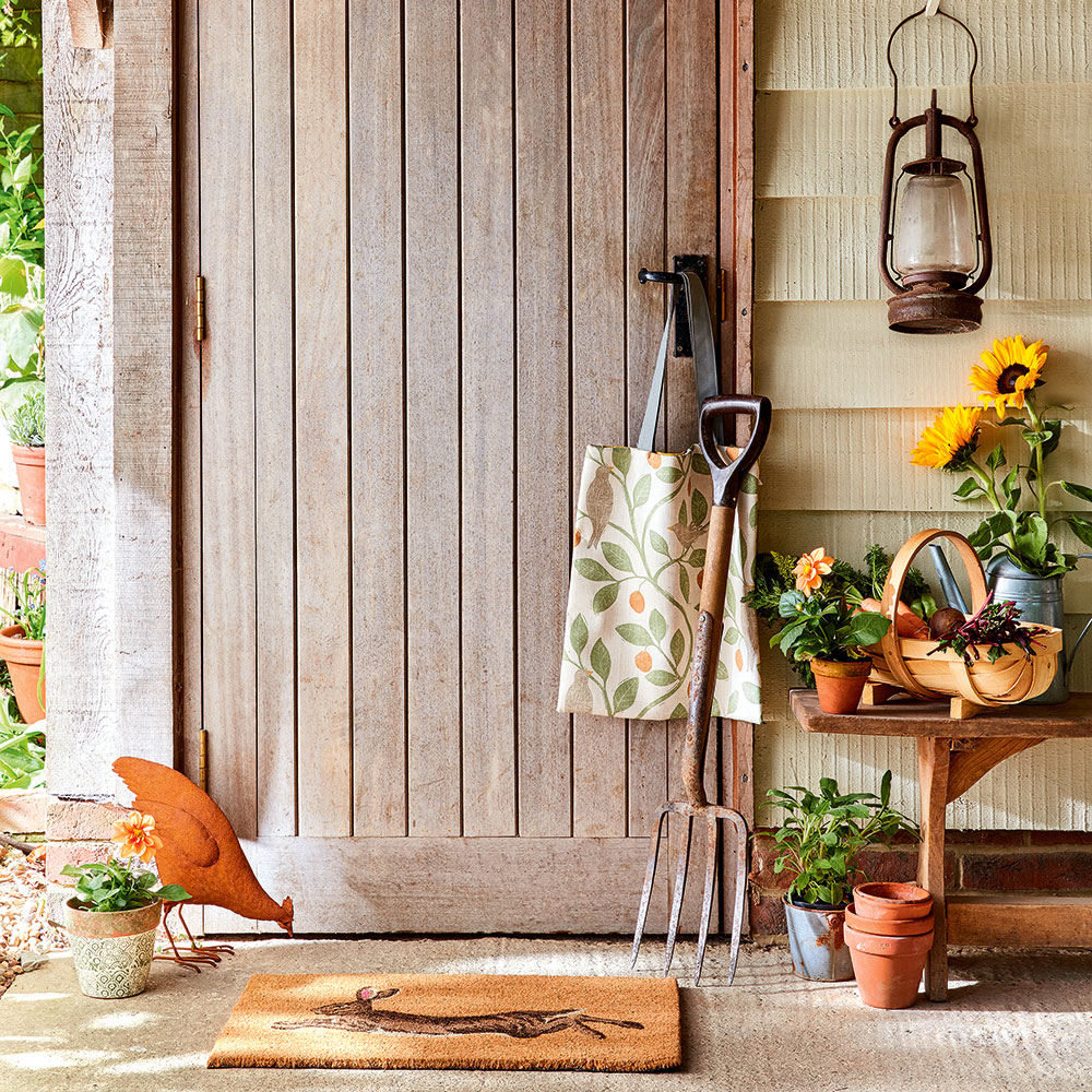 room with wooden door wooden bench and flowers in pots