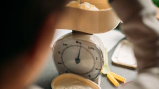 Weighing scales being used to measure out butter