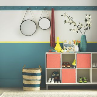 Hallway with half-painted teal wall, and colourful storage unit