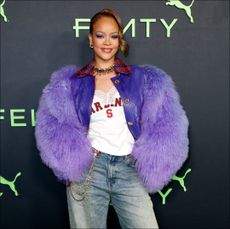 Rihanna in a purple coat, jeans, and jersey at Fenty x Puma's launch party