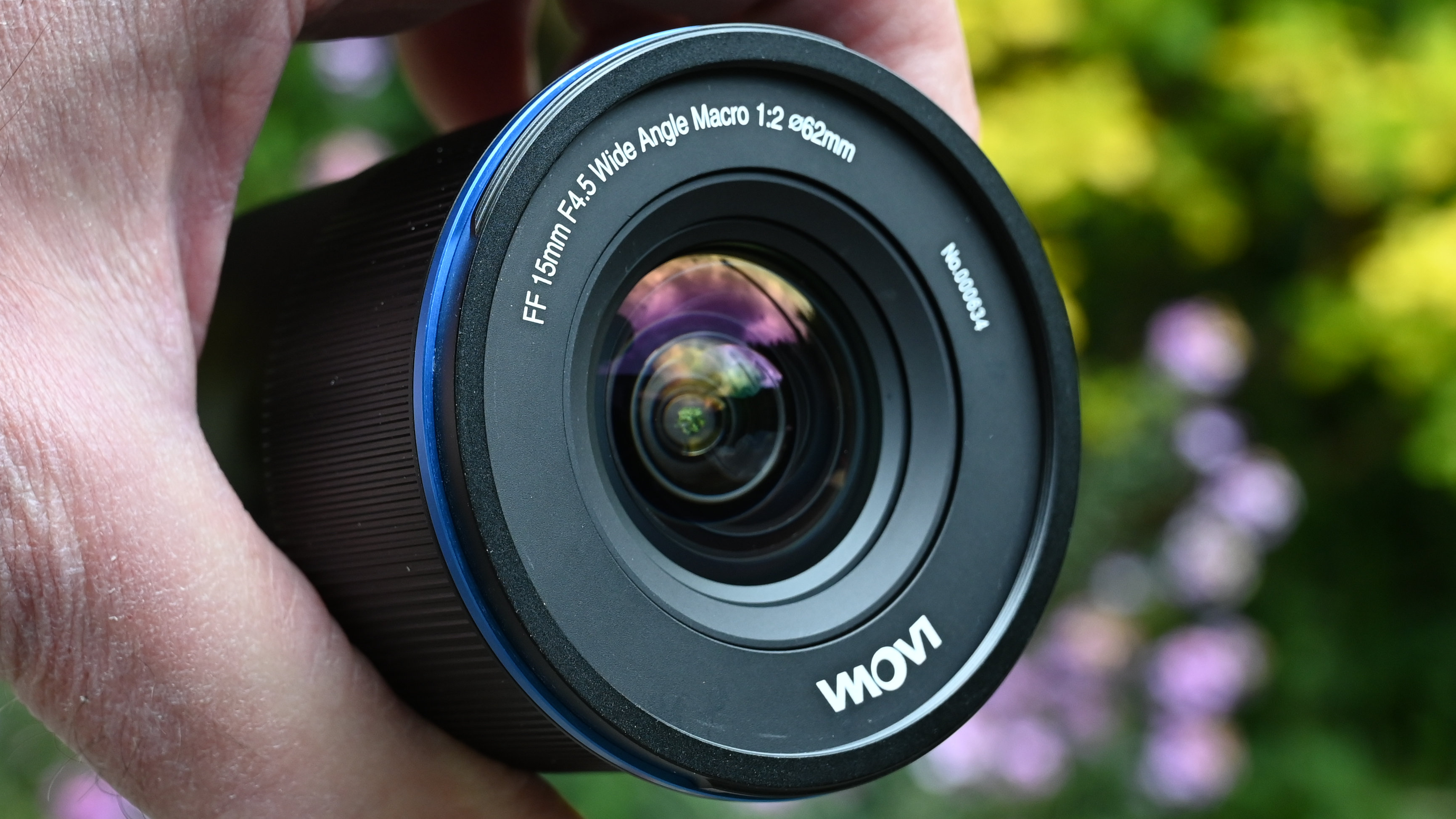 Laowa 15mm f/4.5 0.5x Macro product shot with lens held in hand