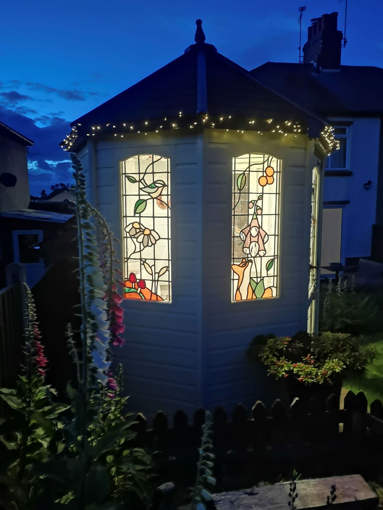 A well lit shed at night with designed windows on the wooden modest hexagonal shed