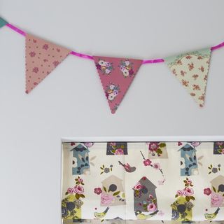 white wall with rose colour printed bunting