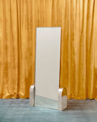 Full height mirror by Sight Unseen in front of a yellow curtain