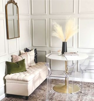 White round dining table with clear chairs and pampas on the top, side seater dressed with cushions