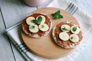 How soon after eating can I exercise? Healthy vegan snack or breakfast meal made of puffed rice cakes, peanut chocolate butter, banana and mint