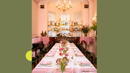 A pink dining room with a table laid with pretty flowers