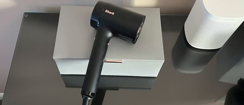 The Shark Style iQ hair dryer on top of a grey box on a dressing table
