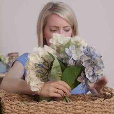 woman placing flower in basket