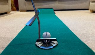 The golf ball lined up on the PGA Tour Indoor & Outdoor Golf Putting Mat