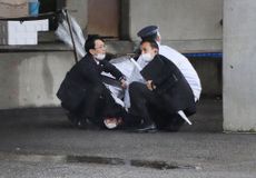 A man is subdued after throwing a device near the Japanese prime minister