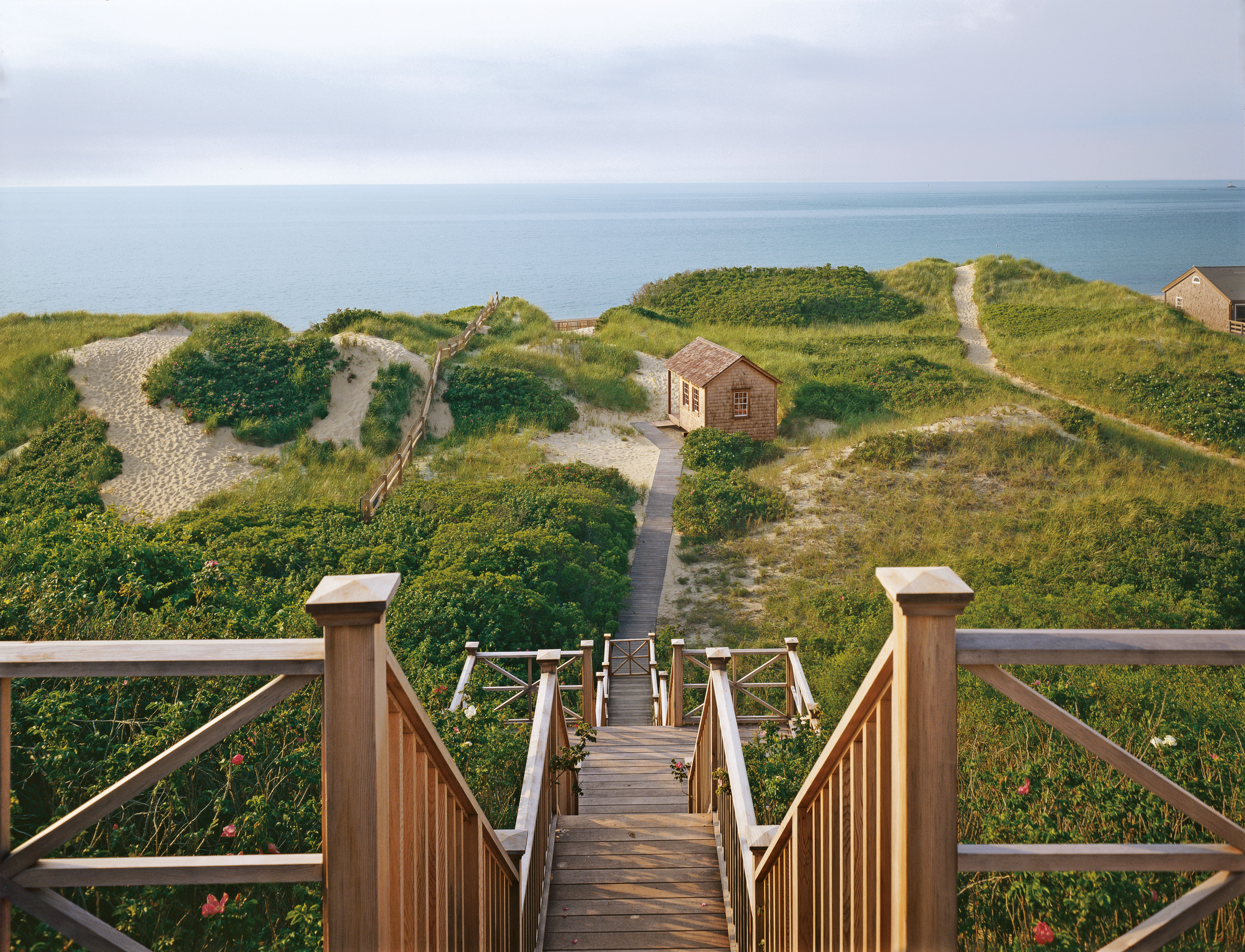 Wooden staircase descending through some sand dunes towards the sea