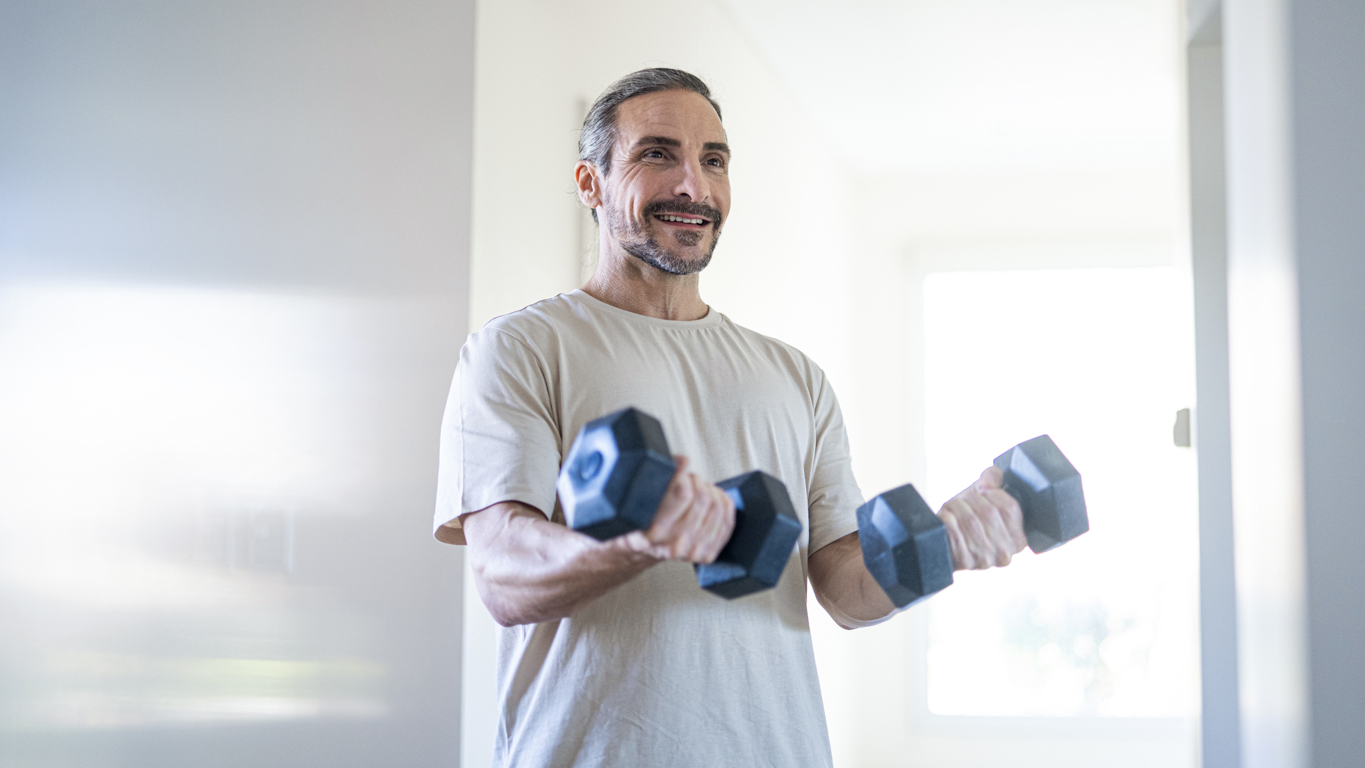 Man exercising with dumbbells at home