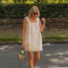 Woman wears white dress, basket bag