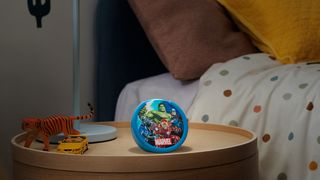 An Amazon Echo Pop Kids with the Avengers theme sitting on a nightstand.