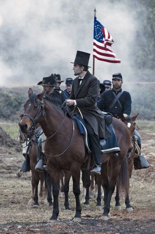 daniel day lewis as abraham lincoln riding on a horse through a battlefield in lincoln