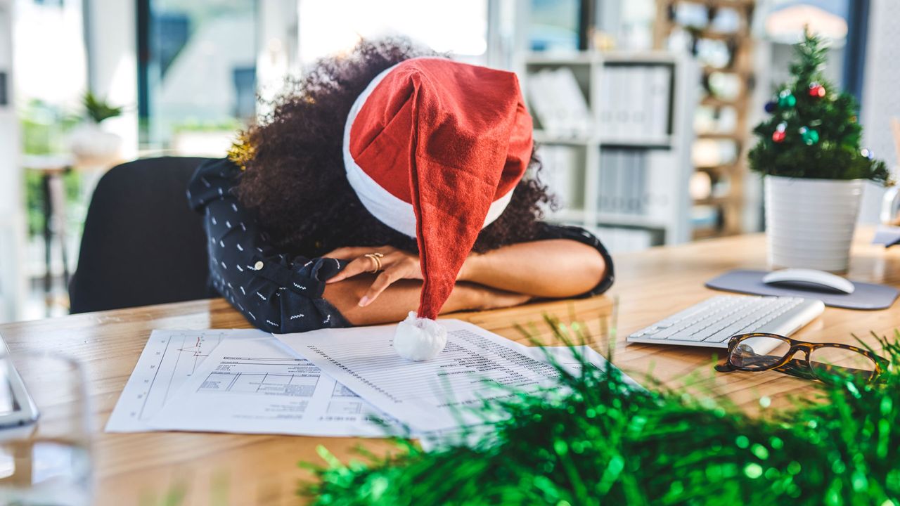 Woman in Santa hat with her head on the table