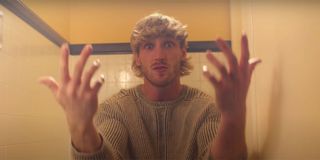 Logan Paul in a music video looking intentionally confused with his hands outstretched.