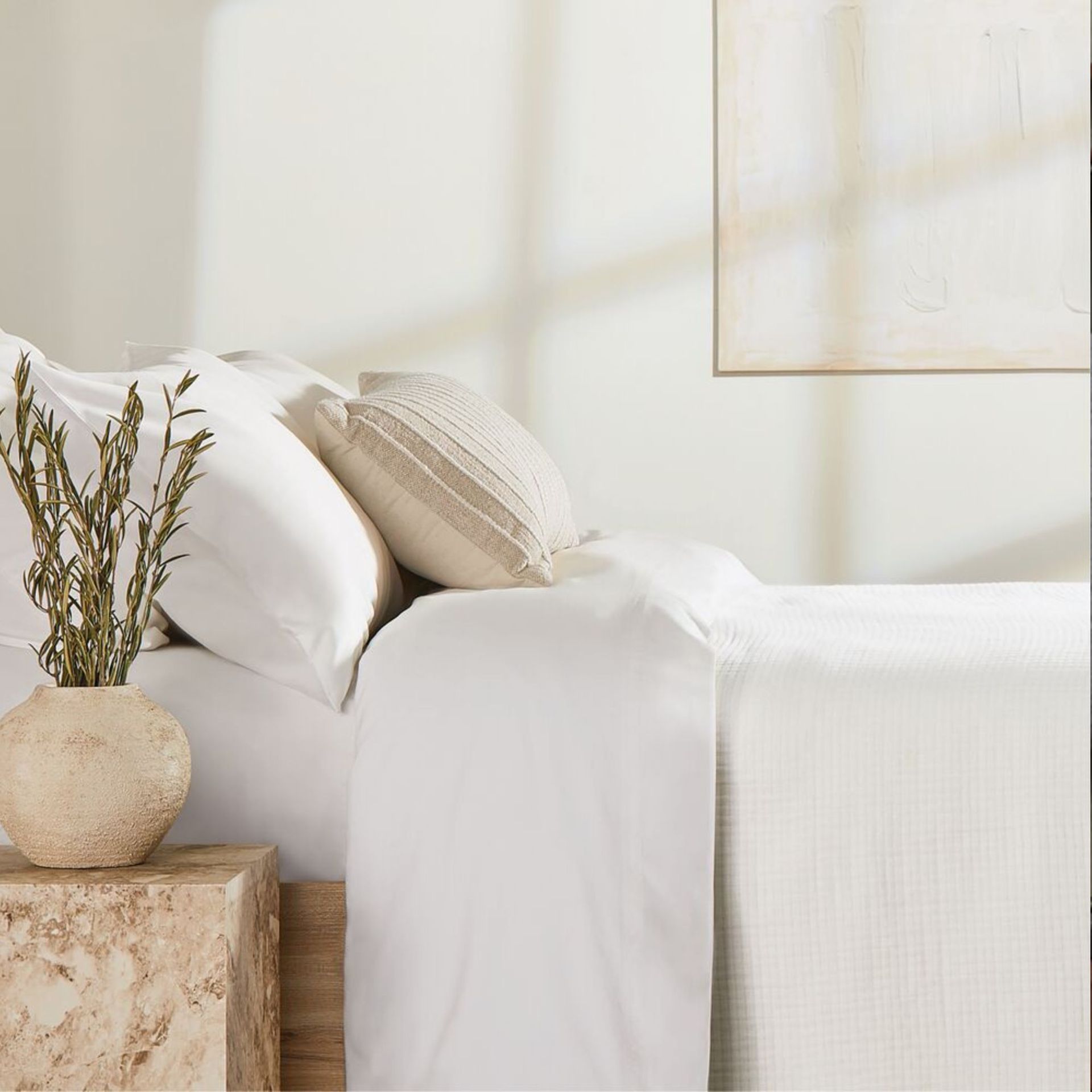 A rectangular throw pillow with stripes on a made bed