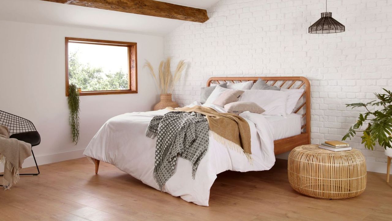 Woolroom bedding on a bed against a white wall in a farmhouse bedroom for a sleep retreat at home.