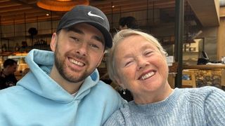 A photo of Charlie Quirke in a light blue hoodie and black baseball cap and his mum Pauline Quirke in a light blue ribbed jumper. They are smiling and looking at the camera.