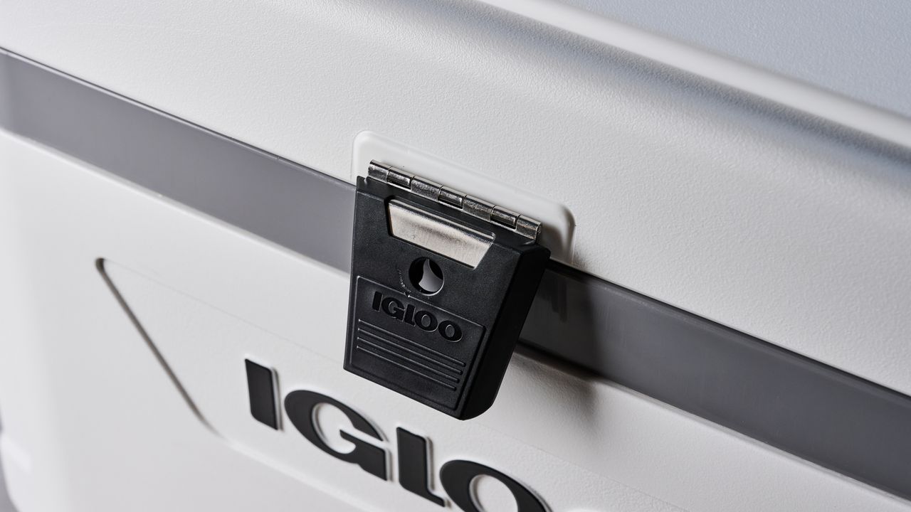 the igloo marine ultra 54 cooler in white with a latch, handles, a big igloo logo on the front and with a fish ruler and drink holders