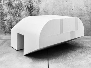 Black and white image of a concrete sculpture in the form of an elongated igloo