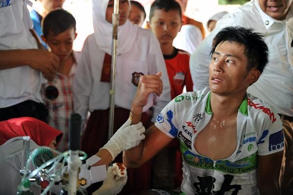 Chun Kai Feng (Action Cycling Team) receives medical attention after crashing in the stage 1 finale.
