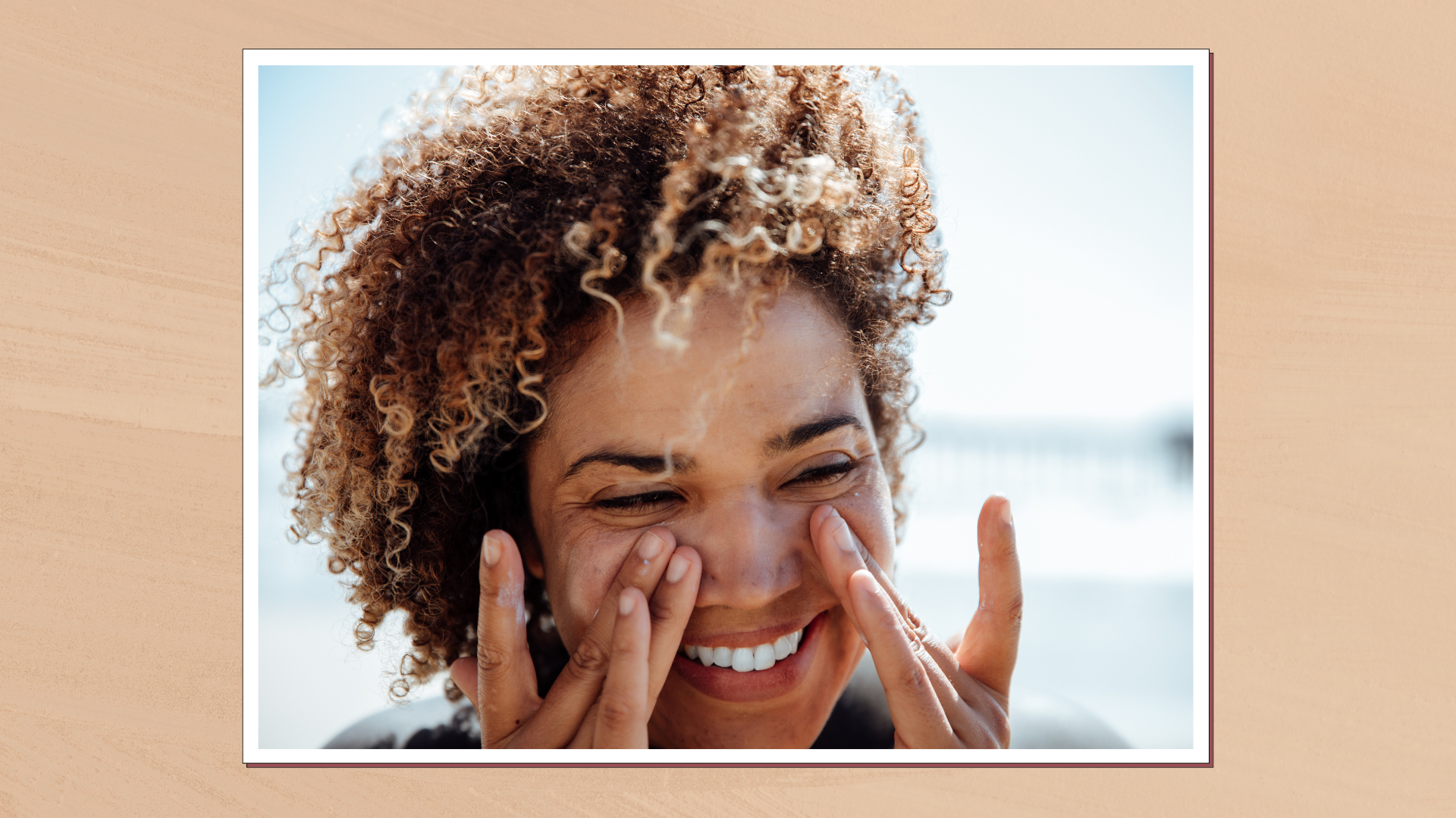Close up image of a woman applying sunscreen, set in a white frame against a warm beige background 