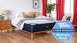 The DreamCloud Hybrid Mattress shown in a bedroom with red curtains, and with a blue Cyber Monday mattress badge overlaid on the image