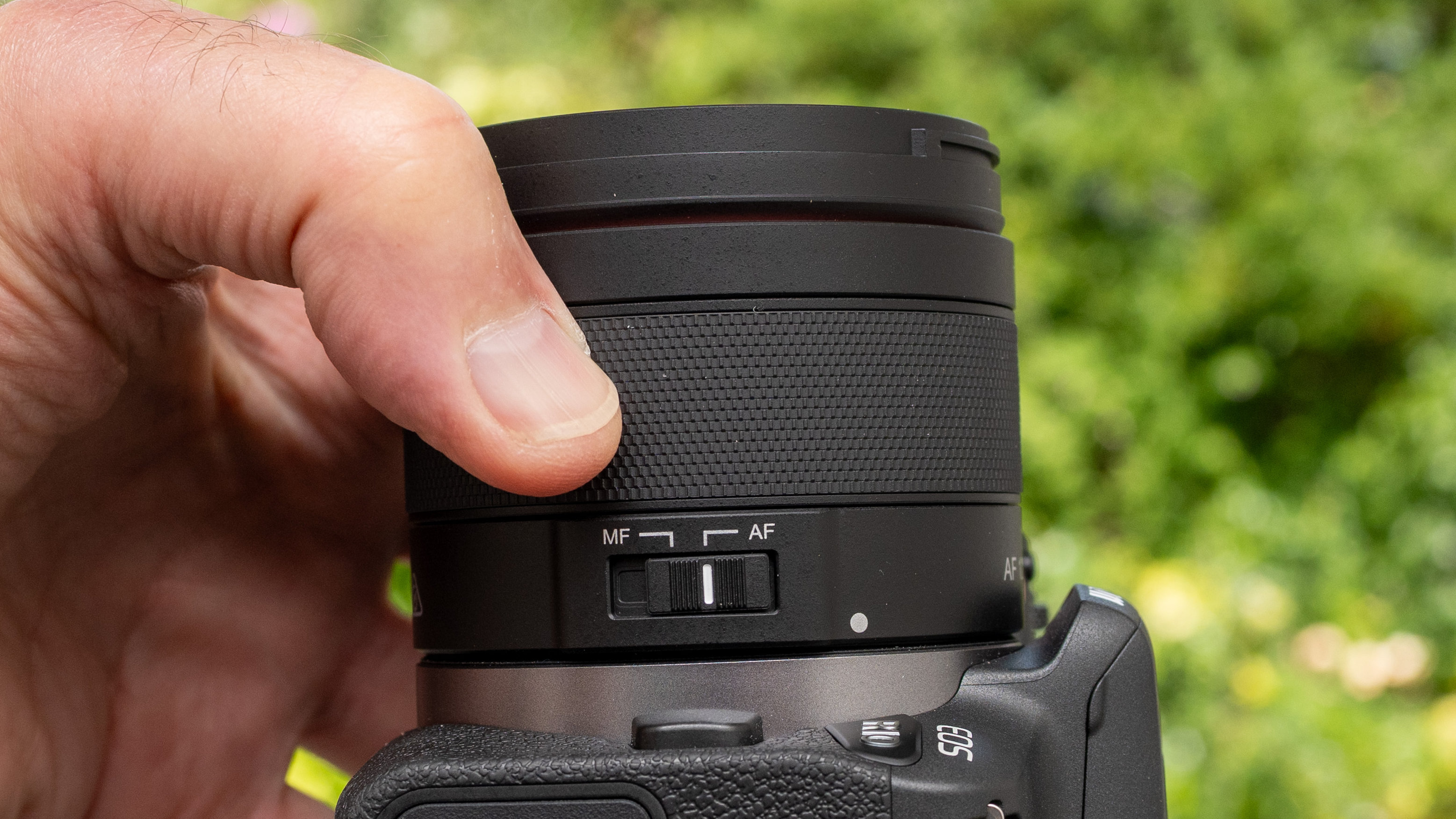 LK Samyang AF 12mm f/2 RF-S product shot lens held in hand