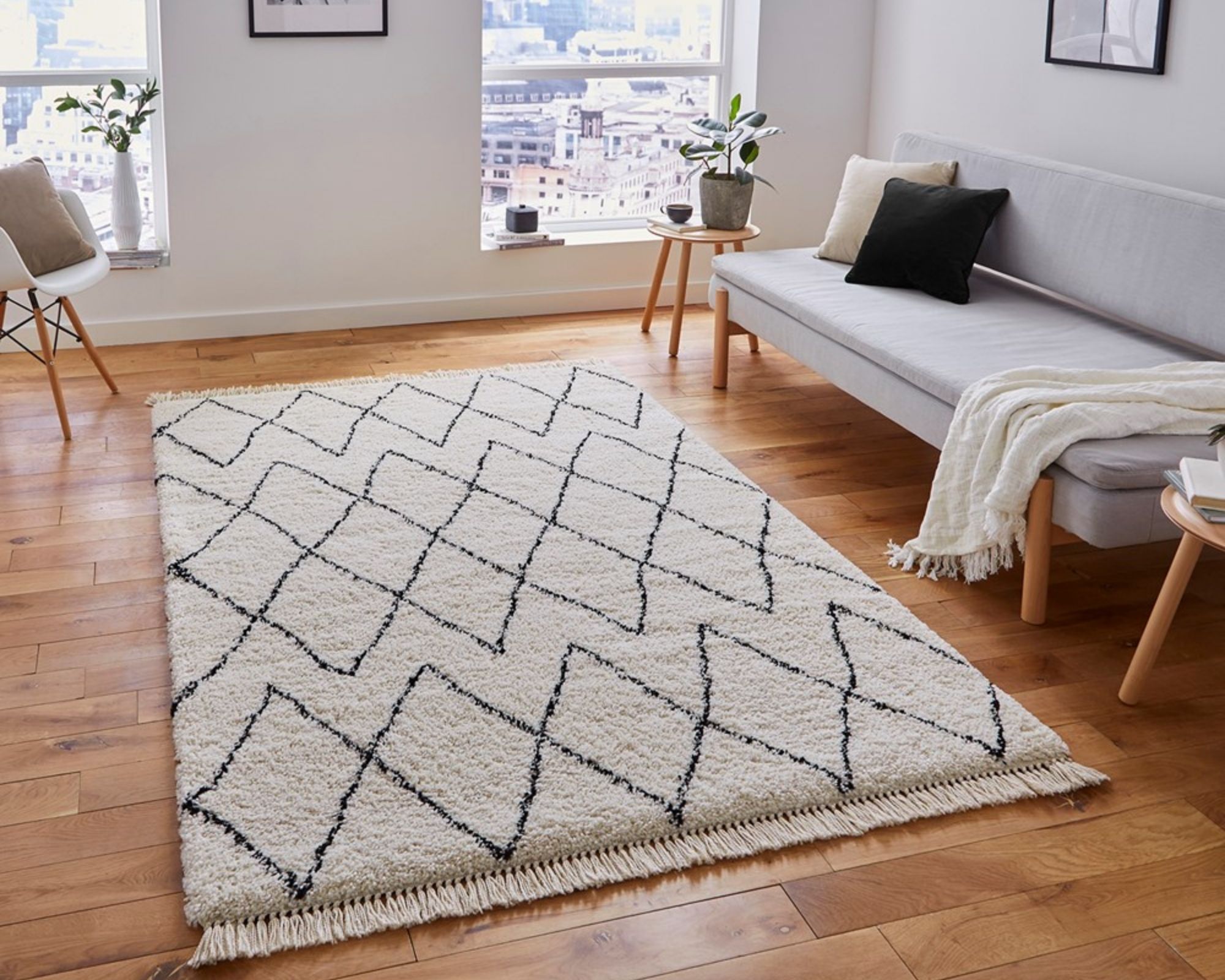 Berber style rug in apartment with wooden floor and grey sofa