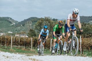 Connor Swift, Matej Mohoric, and Florian Vermeersch lead the way over a gravel sector at the 2023 UCI Gravel World Championships