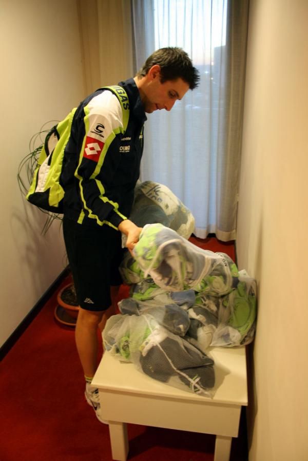 A rider collects his clean kit after it has been washed by the soigneurs